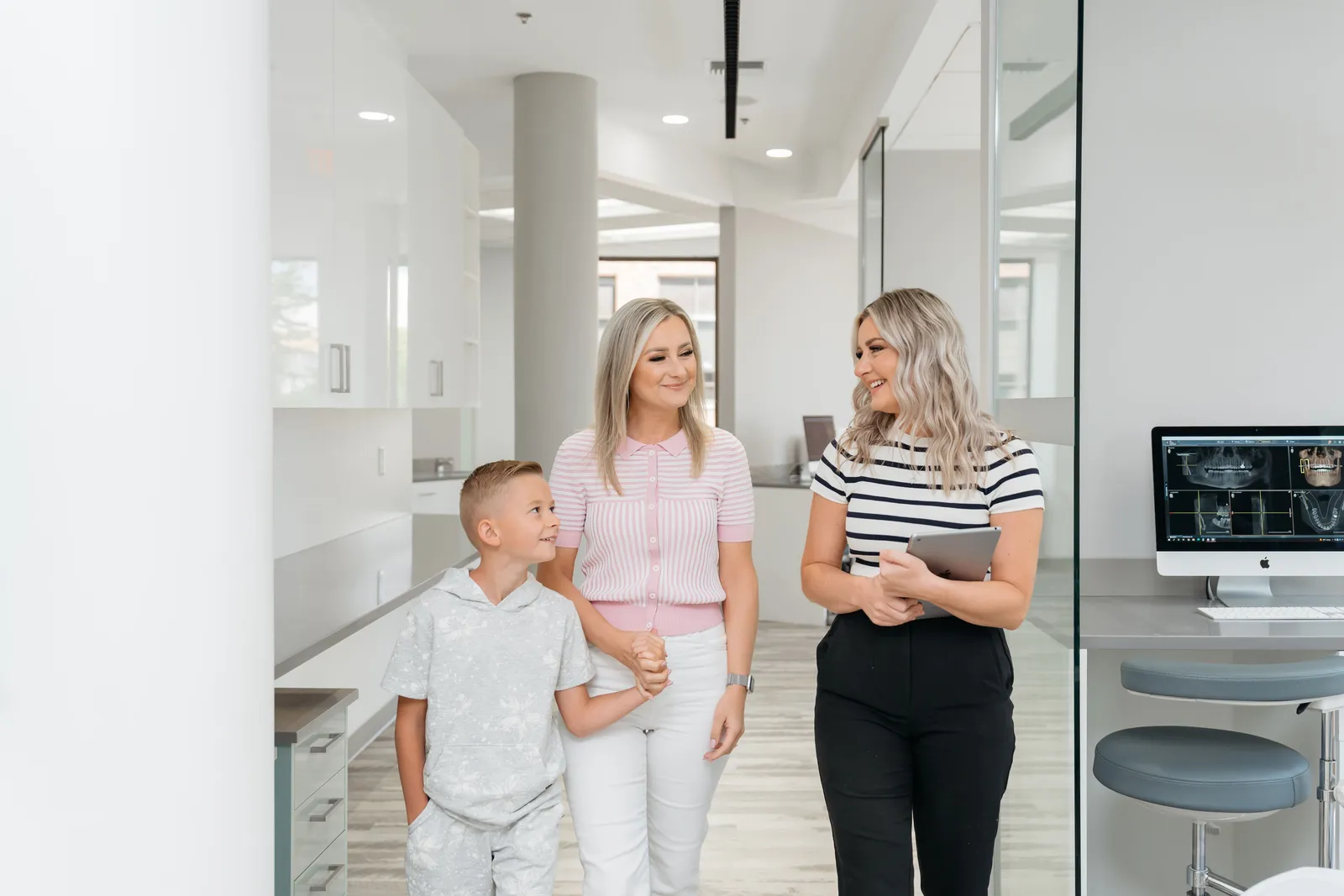 A team member welcoming a family into the office